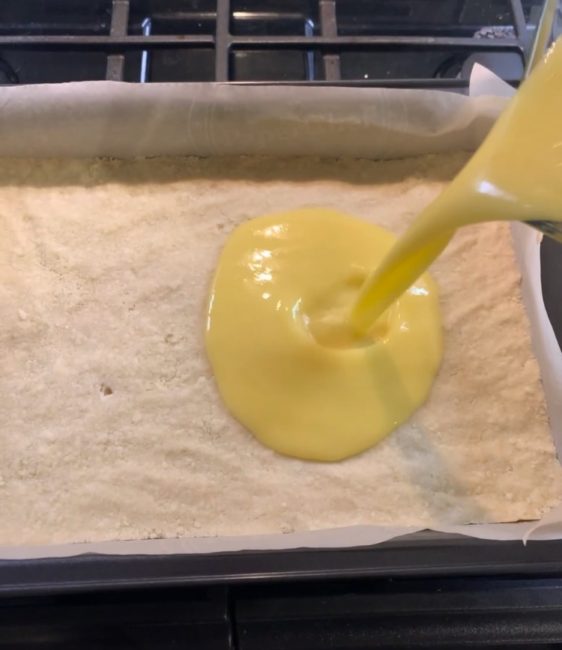 pouring lemon curd onto crust