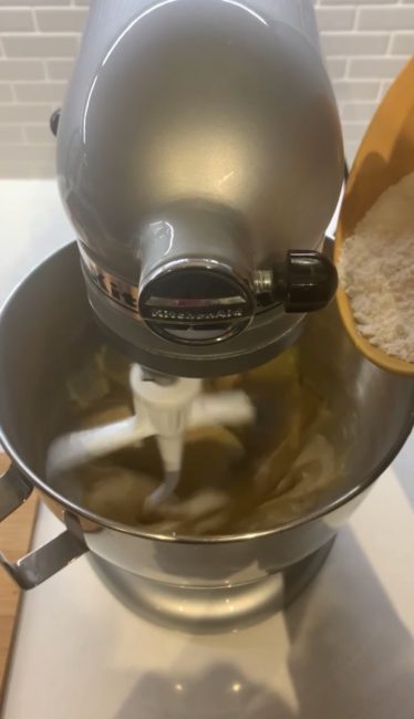 dry ingredients being added to a stand mixer 