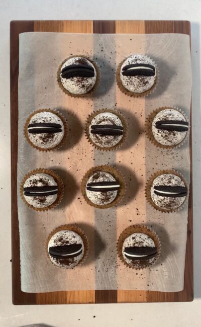 Oreo cupcakes (Oreo cookie sandwich on base, cookies and cream cupcake filling, and Swiss meringue buttercream as frosting). Decorated with Oreo half and additional crushed chocolate cookie crumbs. 