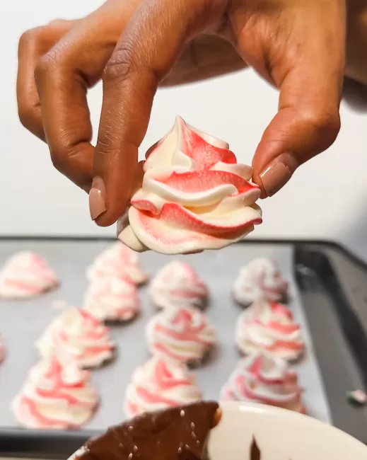 holding a peppermint meringue