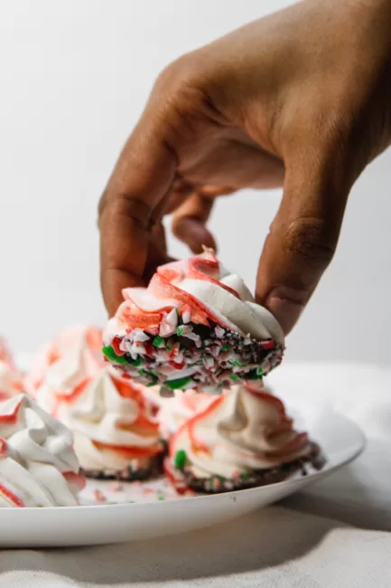 Chocolate Dipped Peppermint Meringues being picked up from a plate