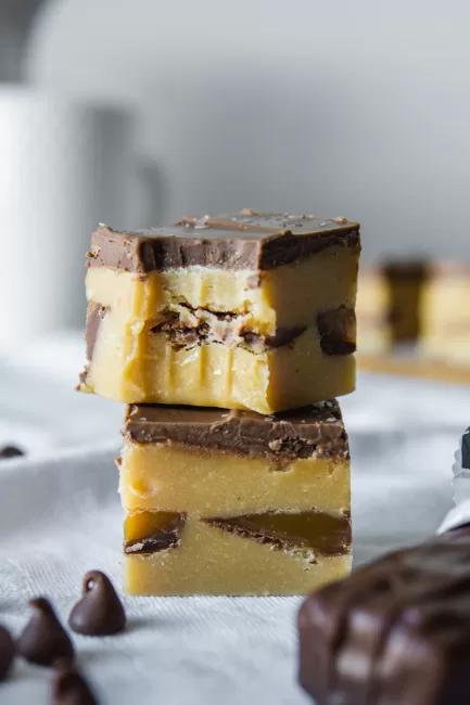 Candy Bar Fudge side view with two stacked on top of each other. one with a bite out of it