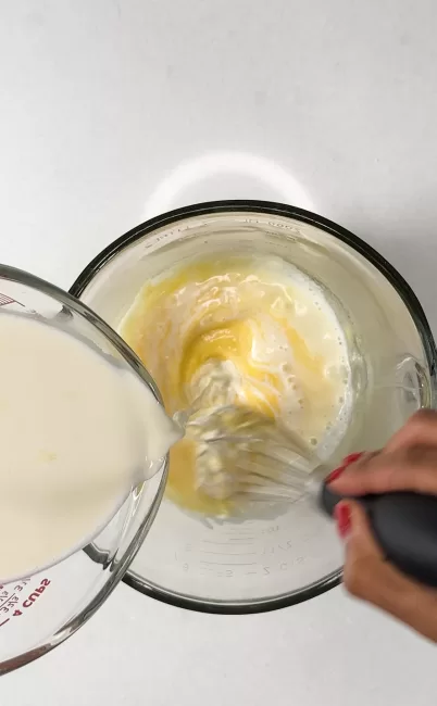 cream mixture being added to egg and sugar
