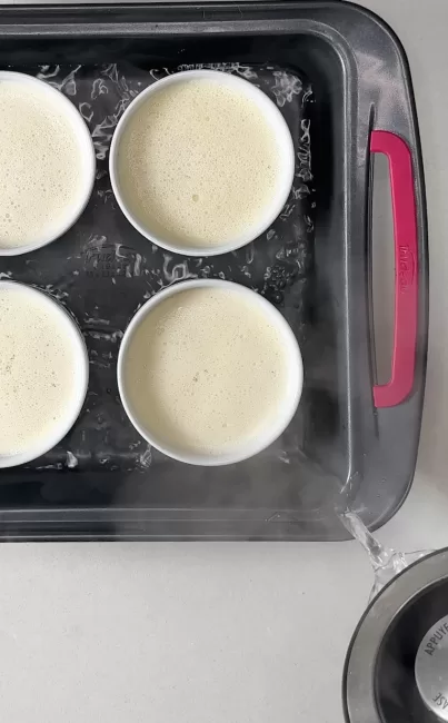 boiling water being poured around ramekins of Crème Brûlée 