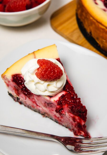 slice of White Chocolate Raspberry Cheesecake on a plate