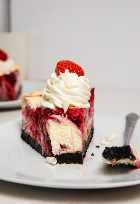 White Chocolate Raspberry Cheesecake  slice with a bite out of the front