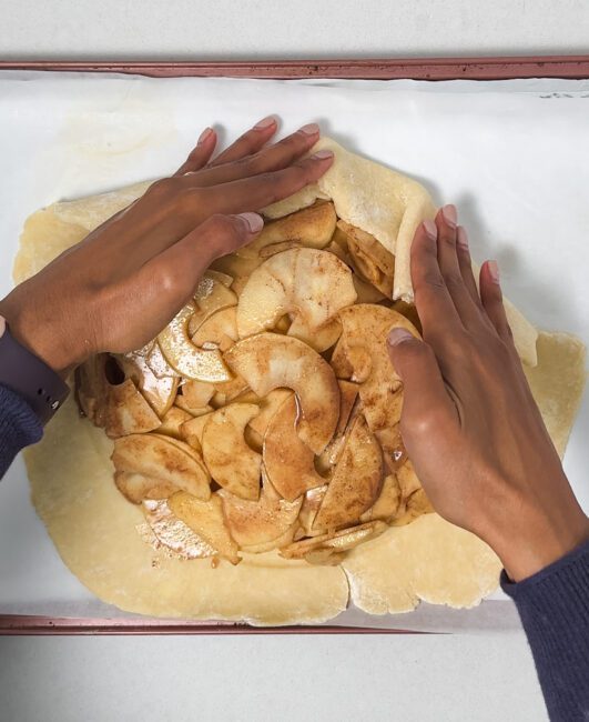 folding dough over the edges of the apple mixture