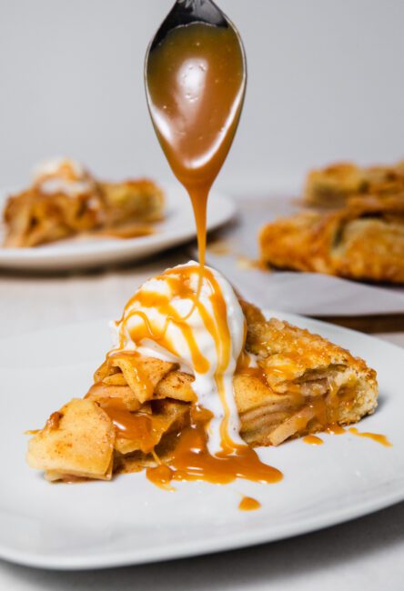 caramel apple galette slice with extra caramel being drizzled on top