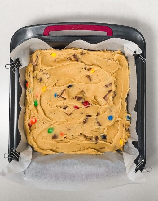 Leftover Candy Bar Blondies batter spread in a 9x9 baking pan