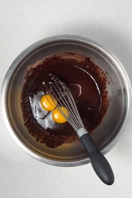 eggs and vanilla added to melted butter, sugars and cocoa powder mixture
